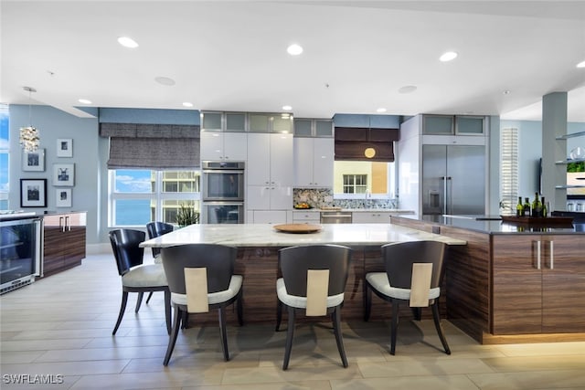 14220 Royal Harbour Ct Unit 607, Fort Myers, FL 33908 - kitchen with appliances with stainless steel finishes, wine cooler, a kitchen bar, modern cabinets, and recessed lighting