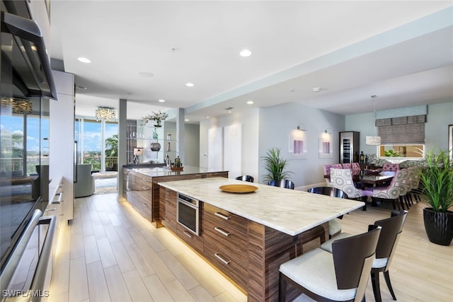 14220 Royal Harbour Ct Unit 607, Fort Myers, FL 33908 - kitchen with modern cabinets, light wood-style flooring, a breakfast bar, light countertops, and open floor plan