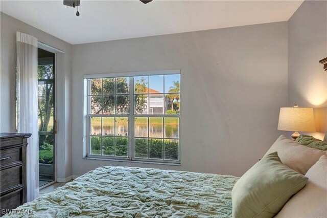 10910 Santa Margherita Rd Unit 101, Estero, FL 34135 - bedroom featuring multiple windows, baseboards, and a water view