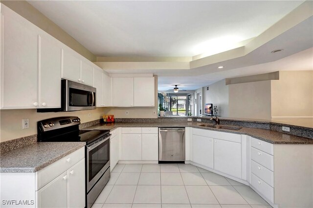 10910 Santa Margherita Rd Unit 101, Estero, FL 34135 - kitchen with stainless steel appliances, a sink, white cabinetry, light tile patterned floors, and recessed lighting