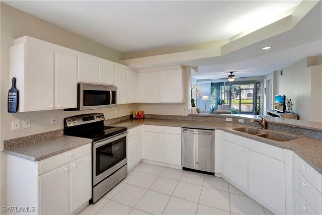 10910 Santa Margherita Rd Unit 101, Estero, FL 34135 - kitchen with stainless steel appliances, a sink, white cabinets, light tile patterned floors, and recessed lighting