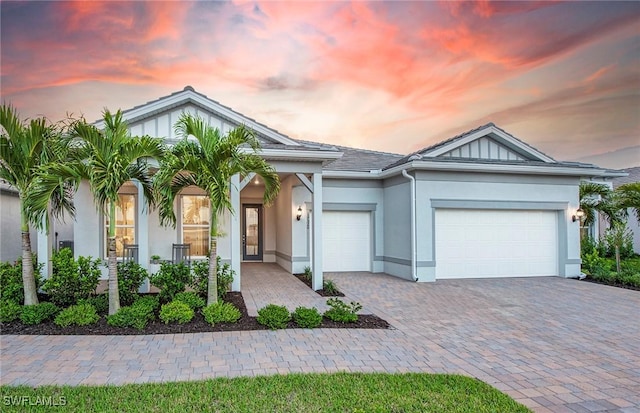 ranch-style house with stucco siding, an attached garage, and decorative driveway