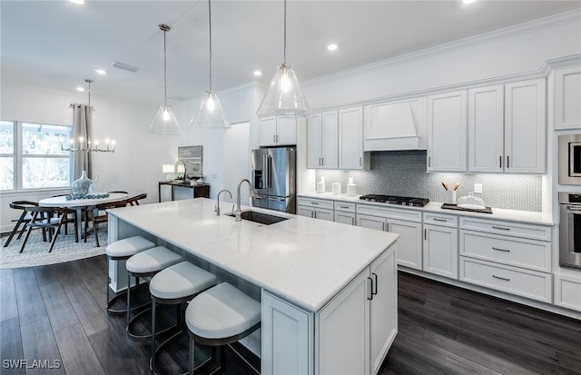 kitchen with a sink, stainless steel appliances, white cabinets, visible vents, and custom range hood
