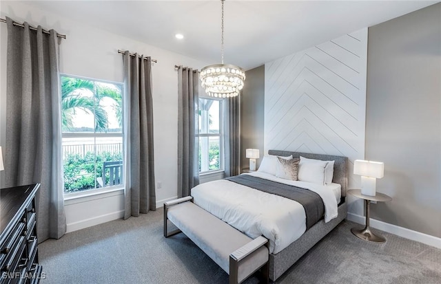 carpeted bedroom with multiple windows, a chandelier, and baseboards