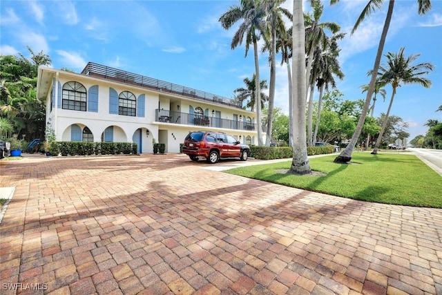 655 8th Ave S Unit 6, Naples, FL 34102 - view of front facade with a front yard, a balcony, and stucco siding