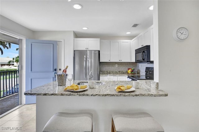 655 8th Ave S Unit 6, Naples, FL 34102 - kitchen with black appliances, a sink, light stone counters, white cabinets, and backsplash