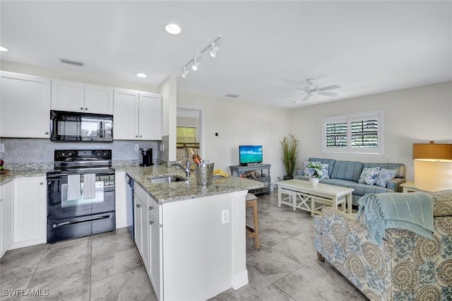 655 8th Ave S Unit 6, Naples, FL 34102 - kitchen featuring black appliances, a sink, open floor plan, white cabinets, and light stone counters
