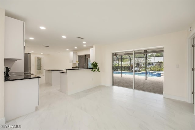 2232 Longboat Dr, Naples, FL 34104 - kitchen with white cabinetry, dark countertops, recessed lighting, a sunroom, and range
