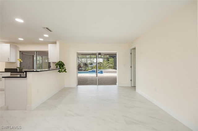 2232 Longboat Dr, Naples, FL 34104 - kitchen with white cabinetry, dark countertops, light marble finish floors, recessed lighting, and baseboards