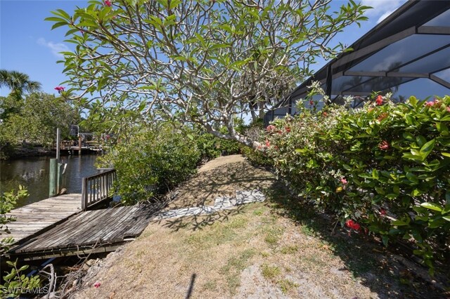2232 Longboat Dr, Naples, FL 34104 - view of yard with a dock, a water view, and glass enclosure