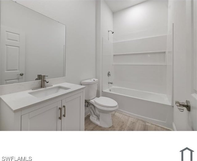 bathroom featuring vanity, toilet, shower / bathtub combination, and wood finished floors