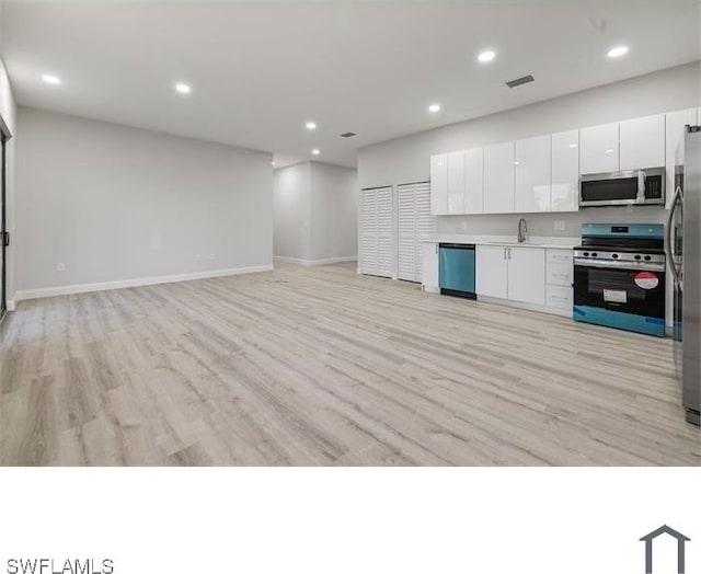 kitchen with visible vents, light wood-style flooring, appliances with stainless steel finishes, and white cabinets