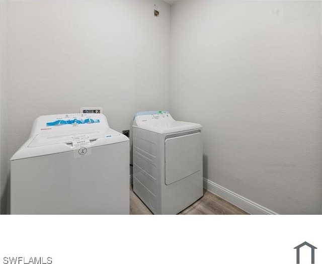 laundry room featuring washer and dryer, laundry area, light wood finished floors, and baseboards