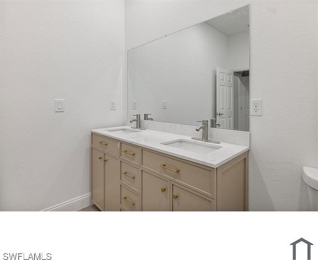 bathroom featuring a sink, double vanity, and toilet