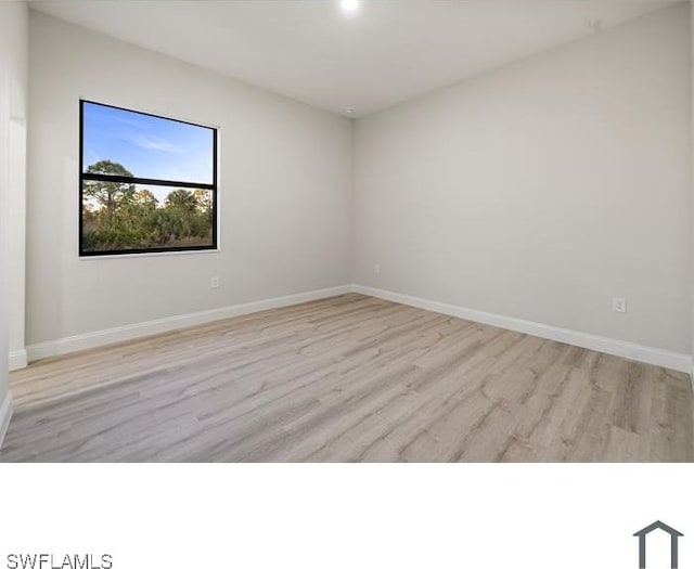 unfurnished room featuring baseboards and wood finished floors