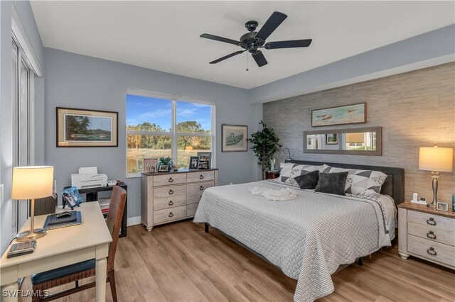 350 Newport Dr Unit 1902, Naples, FL 34114 - bedroom featuring an accent wall, light wood-style floors, baseboards, and ceiling fan