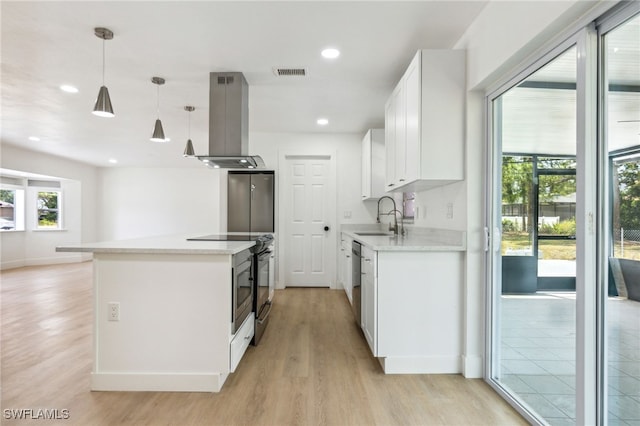 kitchen with a sink, stainless steel appliances, light wood-type flooring, visible vents, and island range hood