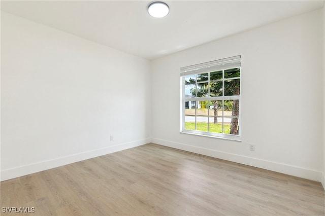 empty room with baseboards and light wood-type flooring