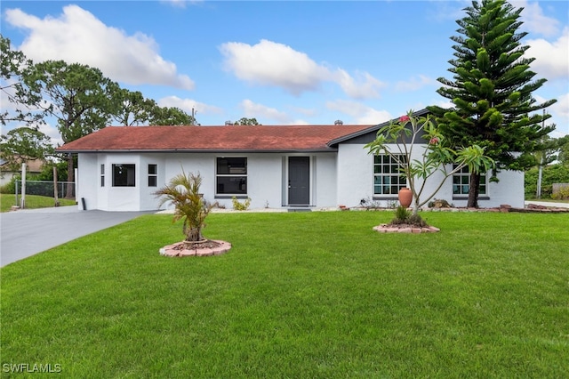 ranch-style home featuring stucco siding and a front yard