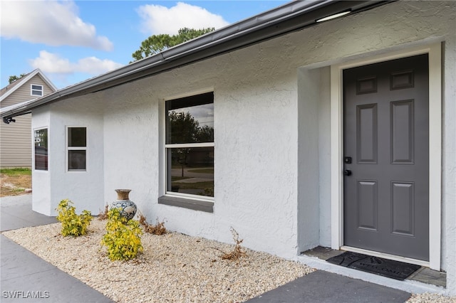 entrance to property with stucco siding