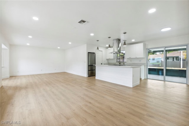unfurnished living room with light wood-style floors, baseboards, visible vents, and recessed lighting