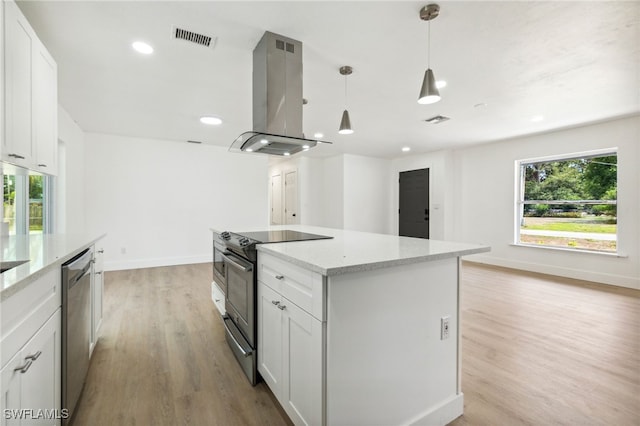 kitchen with stainless steel appliances, island range hood, visible vents, and a wealth of natural light