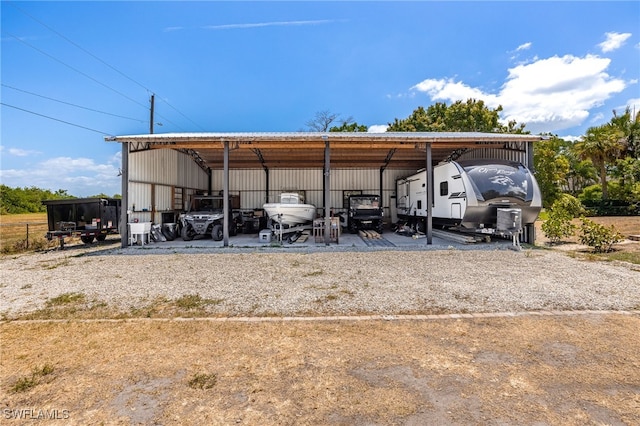 217 W Del Monte Ave, Clewiston, FL 33440 - view of parking / parking lot featuring a carport, an outbuilding, and gravel driveway