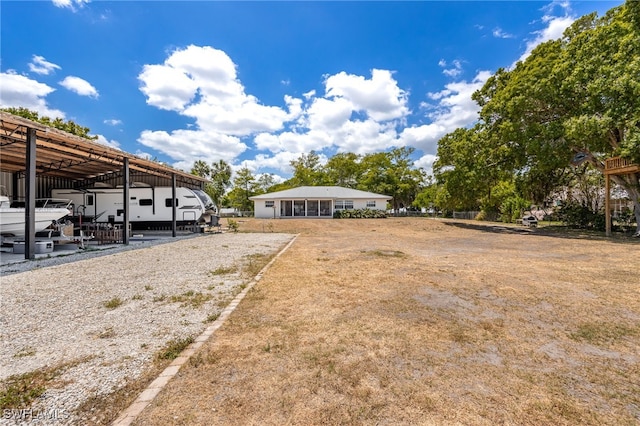 217 W Del Monte Ave, Clewiston, FL 33440 - view of parking featuring a carport and gravel driveway