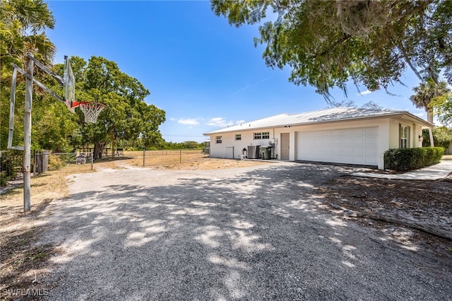 217 W Del Monte Ave, Clewiston, FL 33440 - view of front of home featuring gravel driveway, stucco siding, an attached garage, and fence