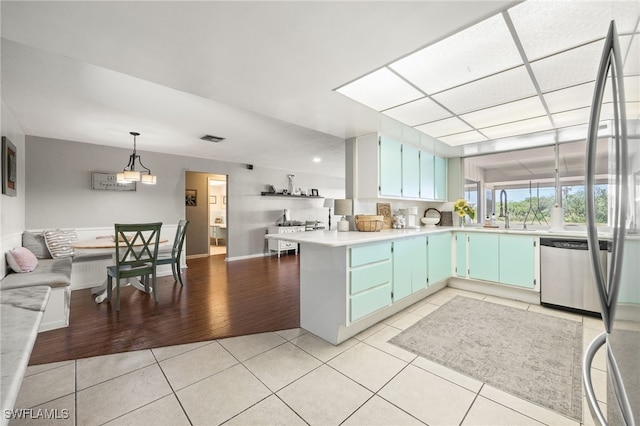 217 W Del Monte Ave, Clewiston, FL 33440 - kitchen featuring stainless steel dishwasher, light tile patterned flooring, visible vents, a peninsula, and light countertops