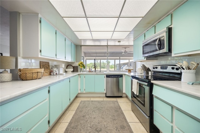 217 W Del Monte Ave, Clewiston, FL 33440 - kitchen with stainless steel appliances, light tile patterned flooring, a sink, light countertops, and tasteful backsplash