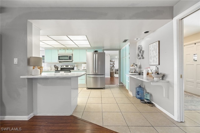 217 W Del Monte Ave, Clewiston, FL 33440 - kitchen featuring a peninsula, light countertops, light tile patterned floors, and appliances with stainless steel finishes