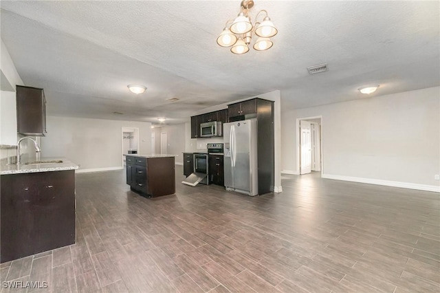 2414 Parkview Dr, Fort Myers, FL 33905 - kitchen featuring appliances with stainless steel finishes, a sink, baseboards, a center island, and dark wood finished floors