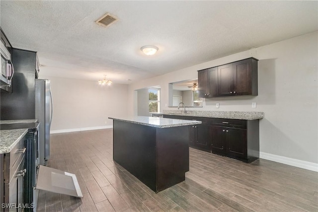 2414 Parkview Dr, Fort Myers, FL 33905 - kitchen with freestanding refrigerator, wood finished floors, baseboards, a chandelier, and a textured ceiling