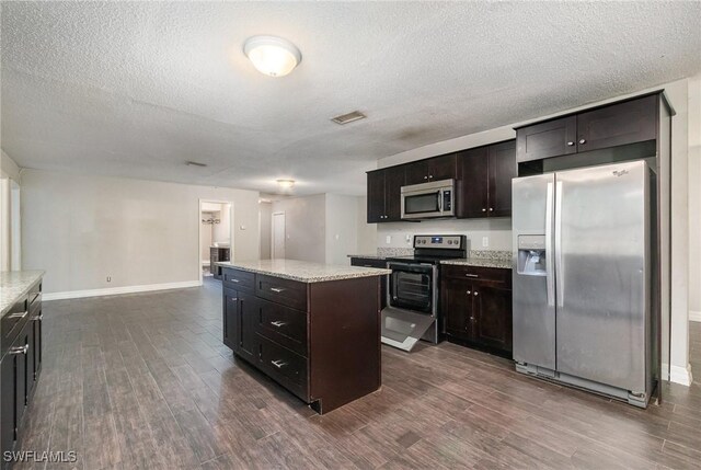2414 Parkview Dr, Fort Myers, FL 33905 - kitchen with appliances with stainless steel finishes, dark wood-style floors, a center island, baseboards, and a textured ceiling