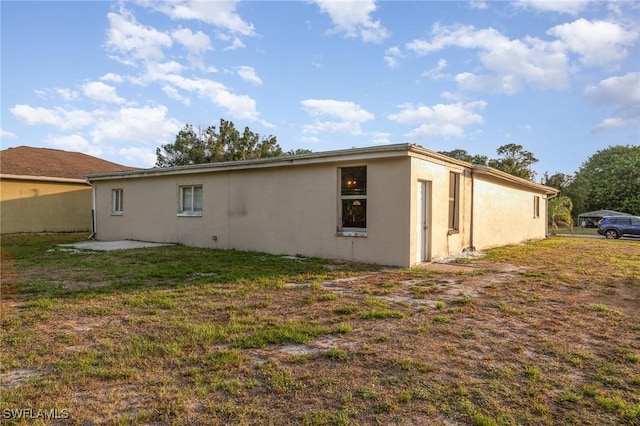 2414 Parkview Dr, Fort Myers, FL 33905 - back of house featuring stucco siding and a lawn