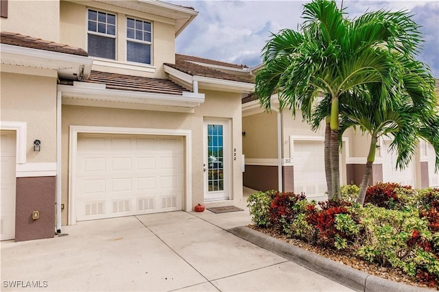 17084 Acapulco Rd Unit 222, Punta Gorda, FL 33955 - property entrance featuring stucco siding, concrete driveway, an attached garage, and a tiled roof