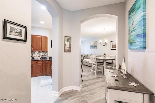 17084 Acapulco Rd Unit 222, Punta Gorda, FL 33955 - hallway with arched walkways, light wood-type flooring, baseboards, a chandelier, and recessed lighting