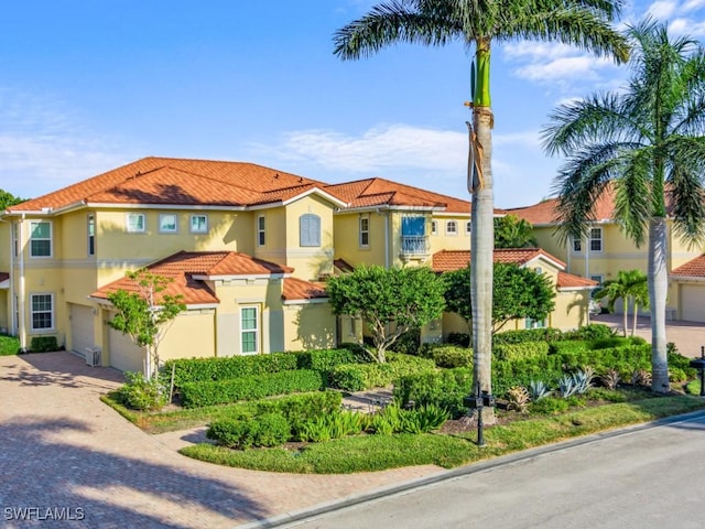 1264 Rialto Way Unit 201, Naples, FL 34114 - mediterranean / spanish-style home featuring a tiled roof, stucco siding, decorative driveway, and a garage