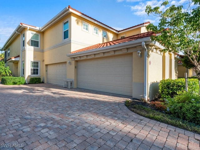 1264 Rialto Way Unit 201, Naples, FL 34114 - view of front of home with stucco siding, a tiled roof, and decorative driveway