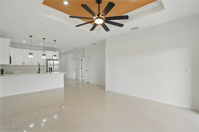 empty room featuring a tray ceiling, recessed lighting, a sink, ceiling fan, and light tile patterned flooring
