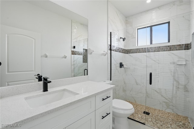 full bath featuring toilet, vanity, and a shower stall