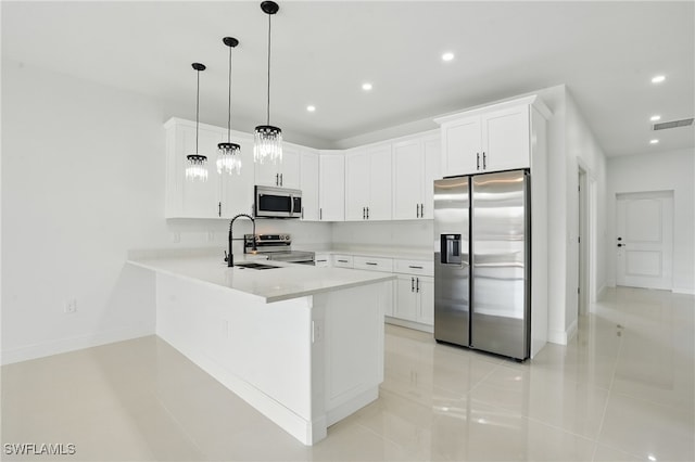 kitchen with appliances with stainless steel finishes, light tile patterned floors, a peninsula, light countertops, and recessed lighting