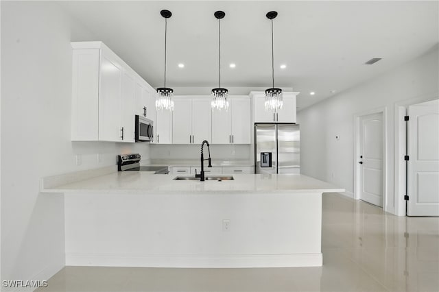 kitchen featuring appliances with stainless steel finishes, a sink, a peninsula, light countertops, and recessed lighting