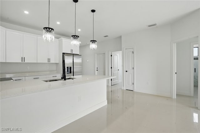 kitchen featuring stainless steel fridge with ice dispenser, a sink, white cabinetry, light tile patterned floors, and recessed lighting