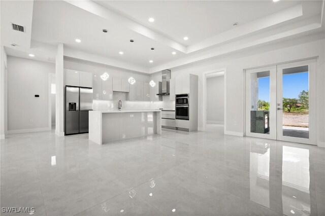 3631 68th Ave NE, Naples, FL 34120 - kitchen featuring stainless steel appliances, wall chimney range hood, modern cabinets, and a raised ceiling