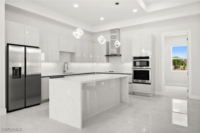 3631 68th Ave NE, Naples, FL 34120 - kitchen with stainless steel appliances, white cabinets, modern cabinets, wall chimney range hood, and a kitchen island