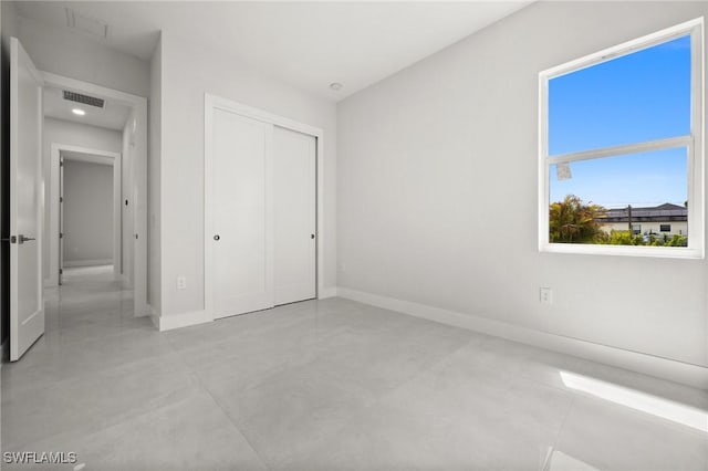 3631 68th Ave NE, Naples, FL 34120 - unfurnished bedroom with finished concrete floors, baseboards, a closet, and visible vents