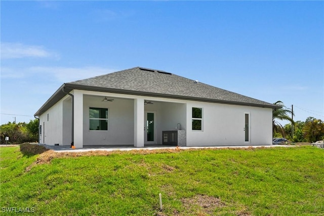 3631 68th Ave NE, Naples, FL 34120 - rear view of house with roof with shingles, a patio, stucco siding, a ceiling fan, and a lawn