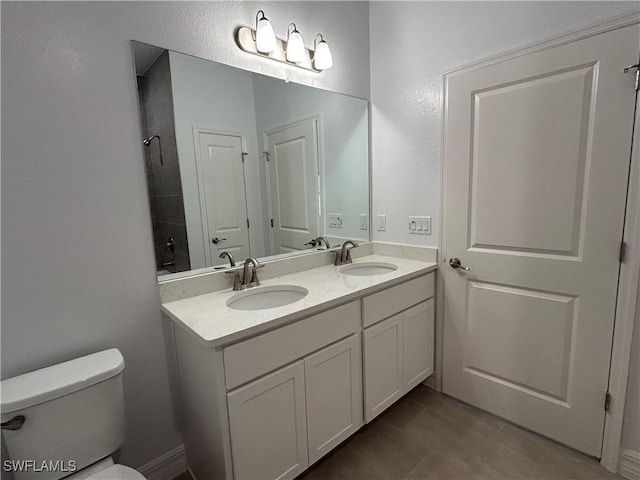 full bathroom with toilet, tile patterned flooring, double vanity, and a sink